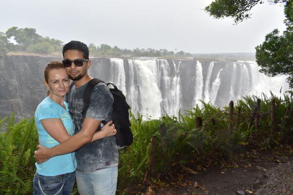 Couple standing in front of Victoria Falls, Zimbabwe