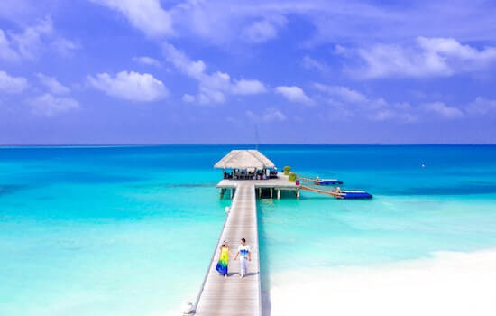 A couple walking on a pier, Maldives