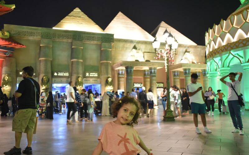 Little girl posing in front of Egyptian Pyramids in Global Village Dubai