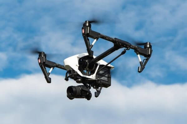 Drone A drone with a camera flying in the sky.