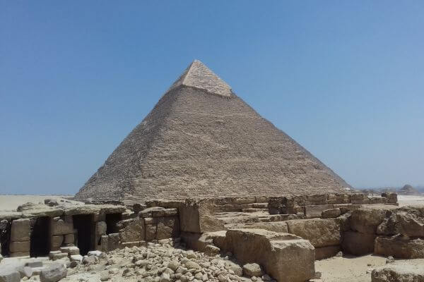 Pyramids of Giza A close up view of one of the Pyramids of Giza in Egypt with stone ruins in the foreground.