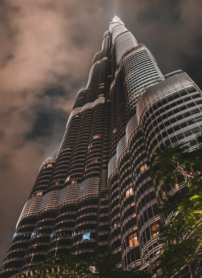 Burj Khalifa Dubai A night view looking up at the Burj Khalifa in Dubai with lights glowing against a cloudy sky.