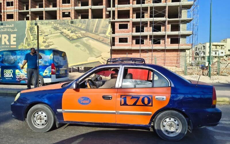 A blue and orange city taxi on the street in Hurghada, Egypt.
