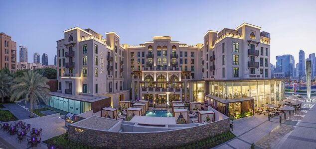 Hotel Boulevard, Autograph Collection in Dubai The front view of Hotel Boulevard, Autograph Collection in Dubai, showing the building lit up in the evening with outdoor dining and seating areas.