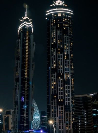 JW Marriott Marquis Hotel Dubai Night view of the twin towers of JW Marriott Marquis Hotel in Dubai, with their lights glowing against the dark sky.