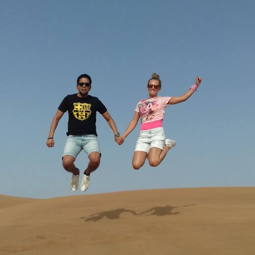 Couple jumping to pose for a picture on desert safari Dubai