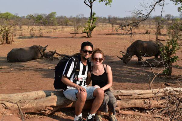 Me and my husband with rhinos behind us during a rhino walk in Zambia