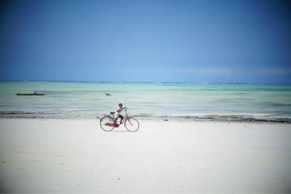 A boy with bicycle on Paje Beach Zanzibar