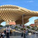 Metropol Parasol (Las Setas) wooden structure in Seville with its wavy design under a blue sky, with visitors walking around the plaza below