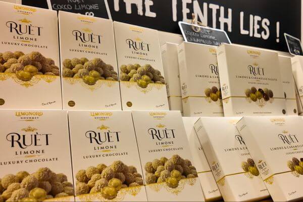 Boxes of Ruèt luxury lemon chocolate by Limonoro Gourmet on a shop shelf on the Amalfi Coast, available in limone and limone and caramello flavours.