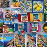 A display of colorful fridge magnets for sale on the Amalfi Coast, showing views of Amalfi, Positano, Sorrento and Capri, as well as lemon designs and little window shutters in typical Italian style.