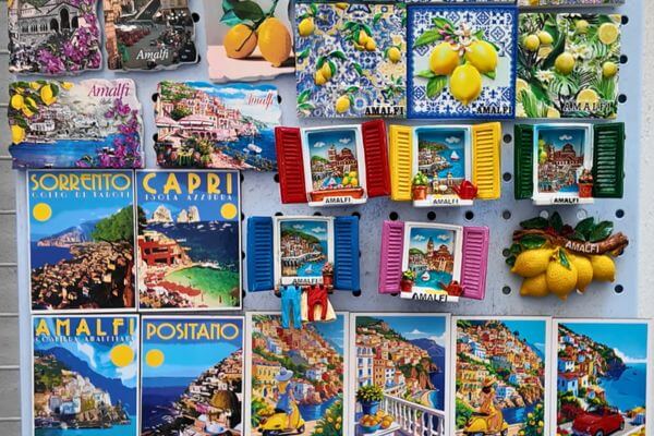 A display of colorful fridge magnets for sale on the Amalfi Coast, showing views of Amalfi, Positano, Sorrento and Capri, as well as lemon designs and little window shutters in typical Italian style.