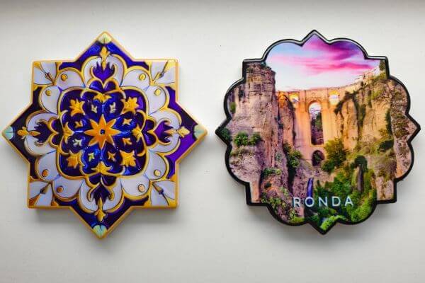 Andalusia, ceramic coasters Two ceramic coasters from Andalusia. One has a blue and gold geometric pattern, the other shows a photo of the famous bridge in Ronda.