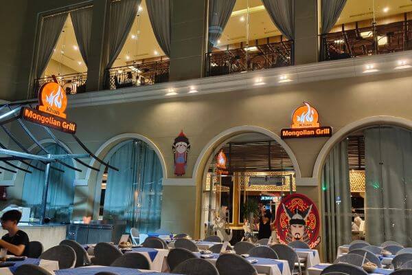 Mongolian restaurant at Titanic Royal The Khan Mongolian Grill restaurant at Titanic Royal Resort in Hurghada, Egypt, with tables and arched entrances.