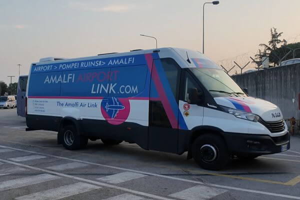 Amalfi Coast Shuttle The Amalfi Airport Link shuttle bus parked at Naples airport, offering transfers to the Amalfi Coast.